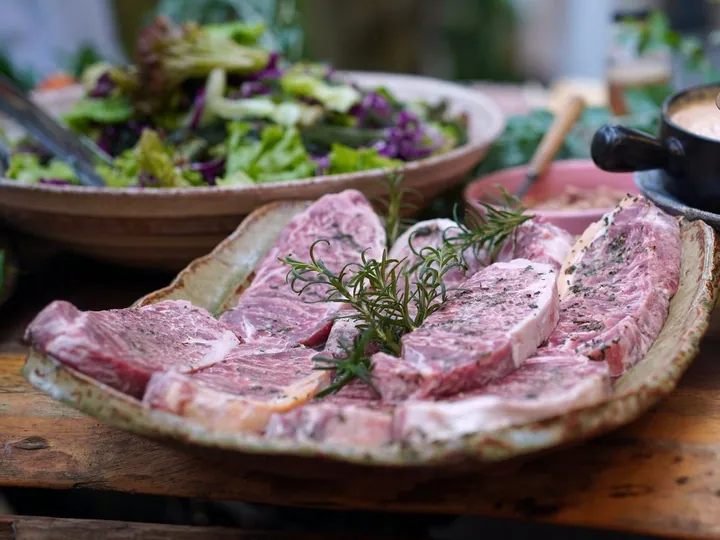 Raw beef steaks with rosemary on a platter