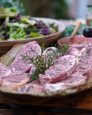 Raw beef steaks with rosemary on a platter
