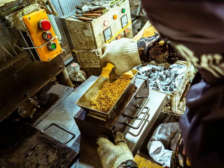Gloved worker operating food processing equipment