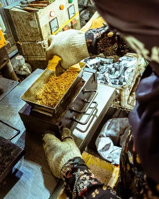 Gloved worker operating food processing equipment
